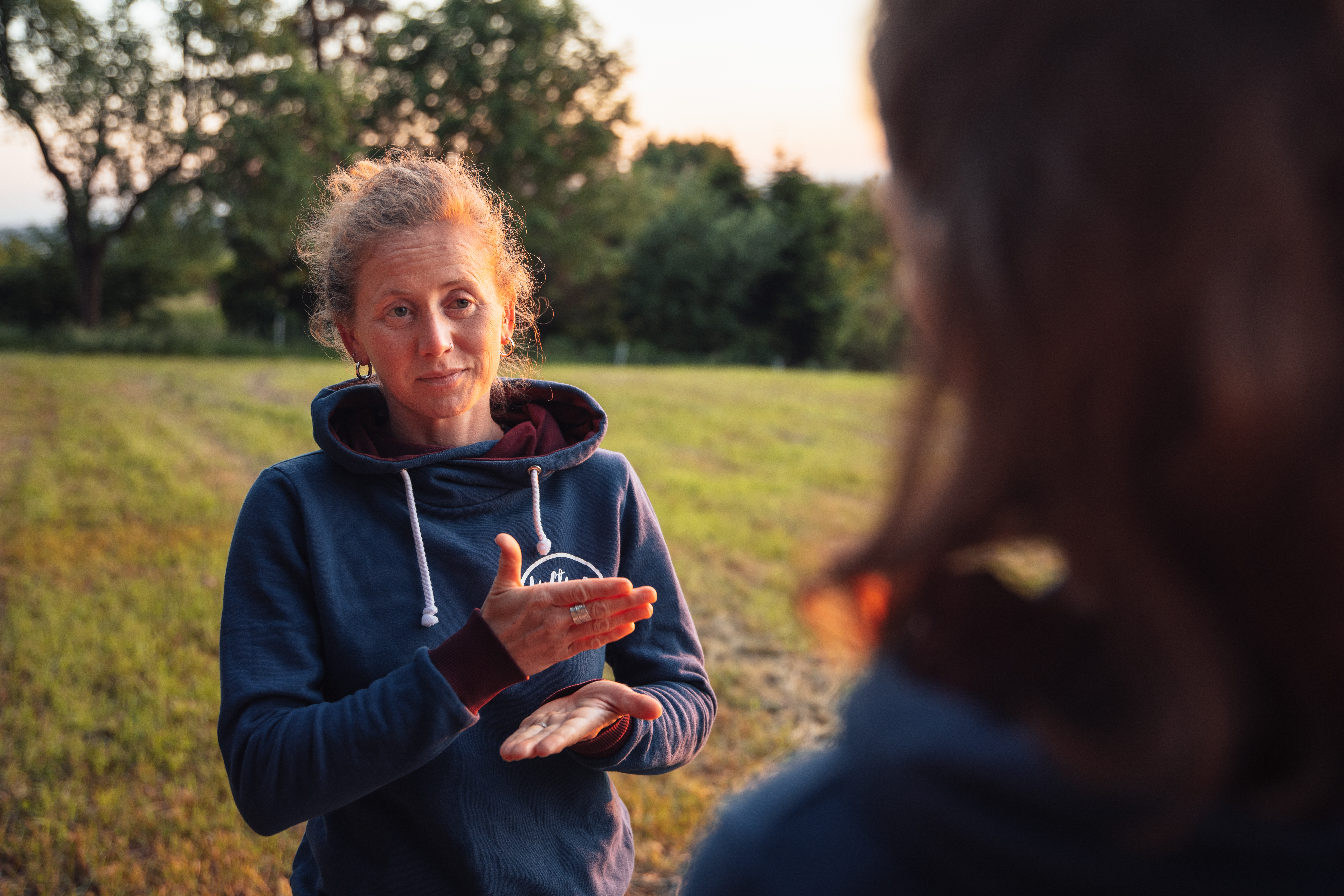 Svenja spricht in Gebärdensprache vor dem Sonnuntergang